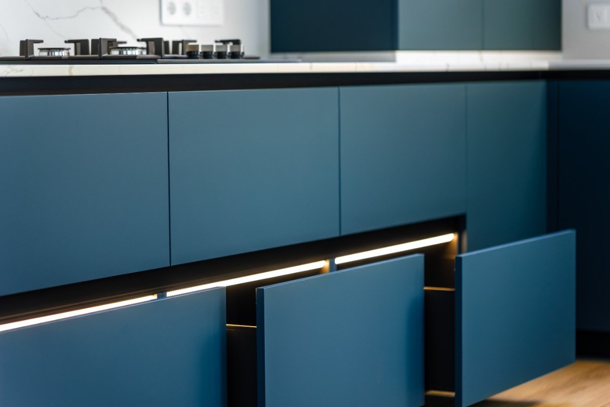 Warm 2026 kitchen cabinet color ideas with cream cabinets, natural wood island, brass hardware, and light countertops