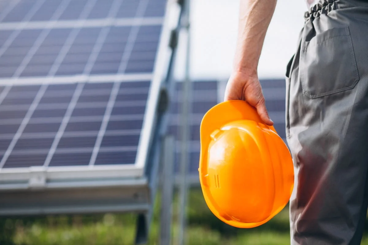Homeowner wearing a roof safety harness preparing a DIY solar panel installation on a residential roof