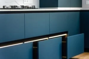 Warm 2026 kitchen cabinet color ideas with cream cabinets, natural wood island, brass hardware, and light countertops